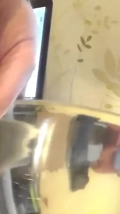 Closeup of John peeing into a steel bowl