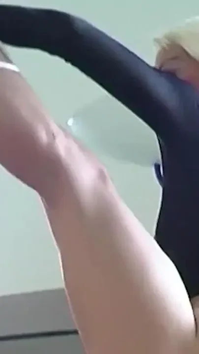 Skinny dancer stretching naked on a glass table