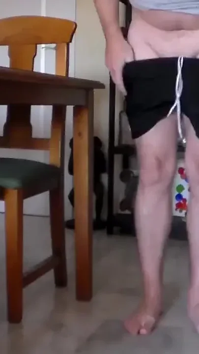 John is sitting on the kitchen table and peeing on the floor