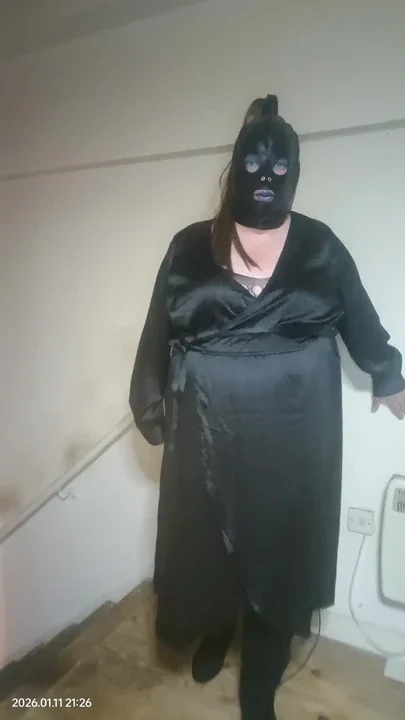 BBW TV poses in satiny black wrap dress