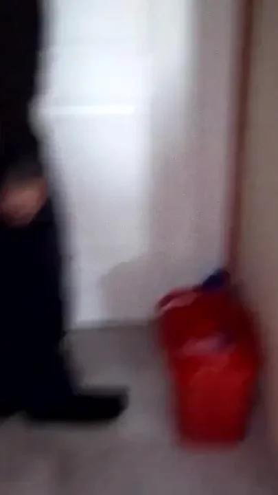 John is taking a piss into the cleaning bucket