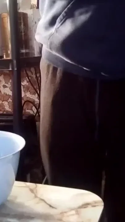 Close up when John is peeing into a plastic bowl