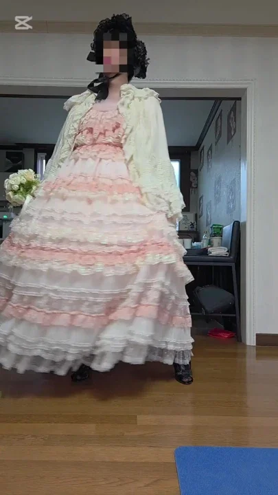 A man dressed as a woman dances in a dress