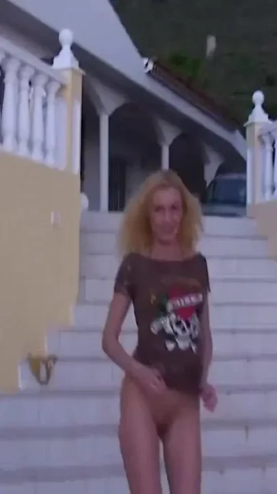 Blonde pissing next to a swimming pool