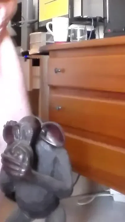 John is peeing on an ape statue