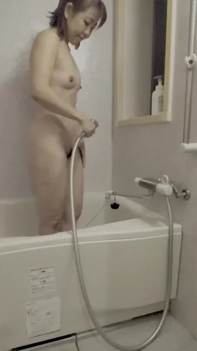 Asian mature woman takes a shower