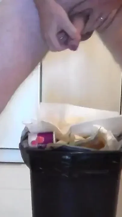 John is peeing into the trashcan