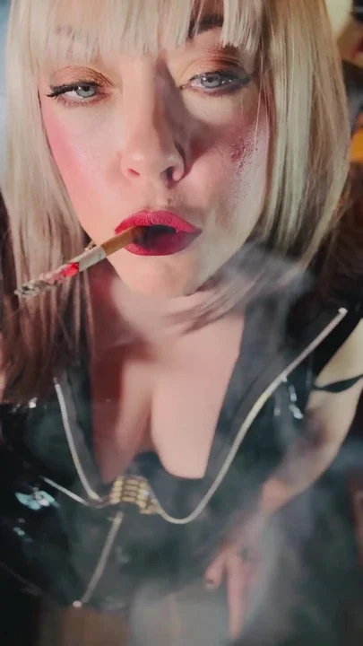 Miss Tina Snua Dressed In PVC & Smoking A Cork Cigarette With Lots Of Dangling