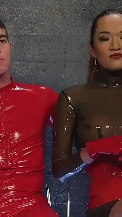 Latex Clad Domme Torments Hard Cocked Slaveboy