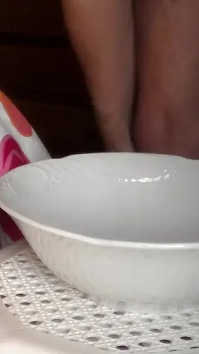 John is peeing into a porcelain bowl