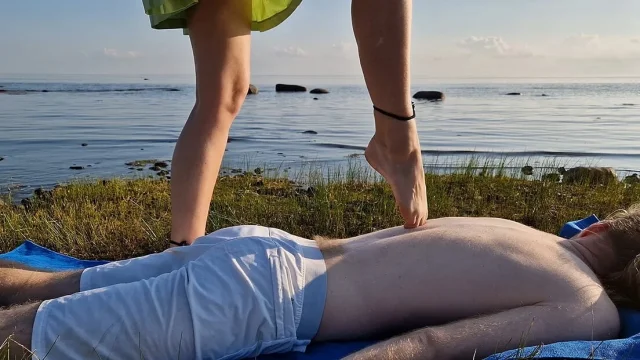 Foot massage by girl with long toes long slim legs in skirt