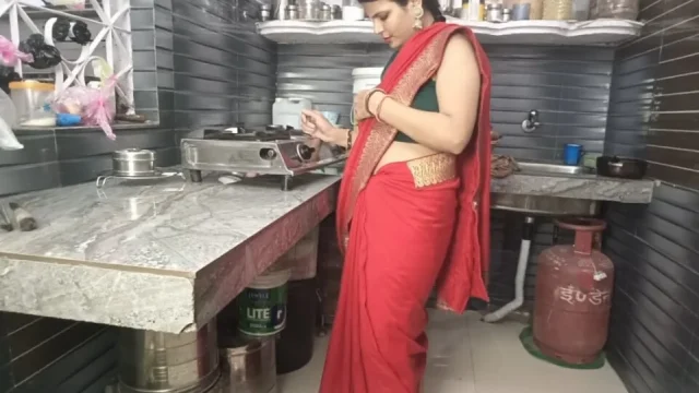 In the kitchen the brother-in-law made the beautiful sister-in-law in red saree