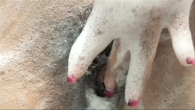 Caressing her sexy body in a bath