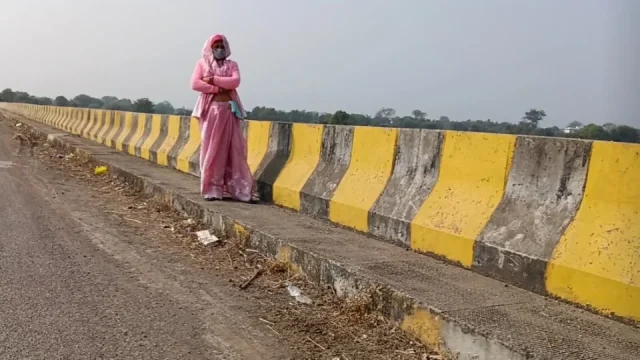 Sister-in-law is walking on the bridge by the roadside getting down on the shore